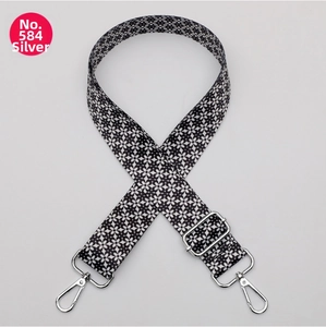 Detail of adjustable crossbody strap with black and white floral pattern and silver hooks