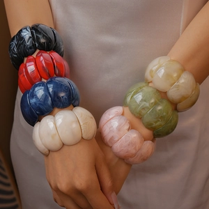 Close-up of colorful resin chunky bracelets with marble texture on model's wrist