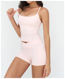 Detail of pink yoga set showing light pink tank top and V-cross waist workout shorts