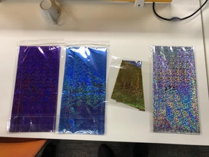 Detail of four laser rainbow party tablecloths in purple, blue, gold and silver foil