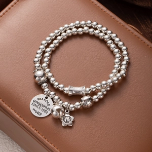Multi-layer silver beaded bracelet with bell and lucky cat fortune charm on leather case