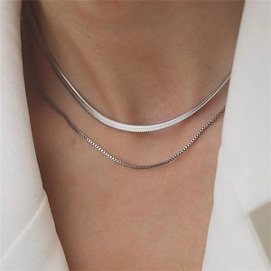 Minimalist double layer silver snake and box chain necklace worn with white suit
