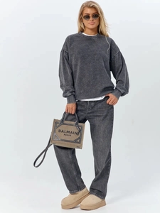 Detail view of washed grey cotton sweatshirt paired with boots and canvas tote bag