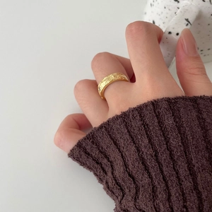 Irregular 925 sterling silver ring with moon texture on a model's hand holding a cup