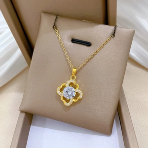 Macro shot of gold four-leaf clover pendant with sparkling crystal inlay in jewelry box
