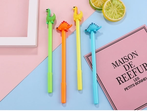 Flat lay of four colorful cartoon dinosaur gel pens with cute 3D soft rubber figures on top