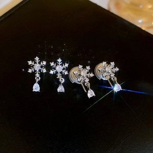 Detail of silver snowflake earrings with cubic zirconia and teardrop charm pendant