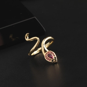 Macro shot of gold snake ring with sparkling red zircon head and detailed crystal eyes