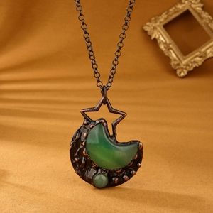 Macro detail of bronze star and moon necklace featuring green aventurine gemstones