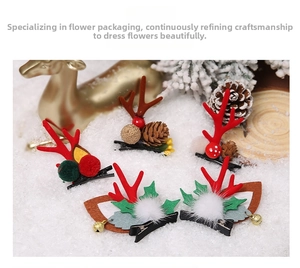 Detail shot of Christmas reindeer horn hair clips with pine cones and holly on snow background