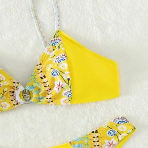 Detail of floral printed bikini top featuring a central silver metallic ring clasp