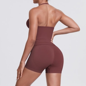 Detail view of high-waist yoga shorts with peach-lift seam and halter neck sports bra