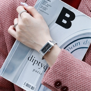 Elegant silver rectangular watch for women with black dial and metal mesh strap on wrist