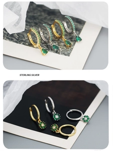 Macro detail of gold and silver sterling silver earrings with emerald green gemstones