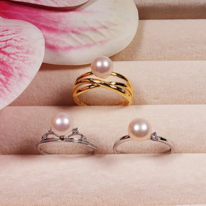Detailed view of pearl rings in gold and silver settings featuring sparkling accents
