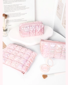 Set de tres neceseres de maquillaje acolchados en color rosa iridiscente de varios tamaños