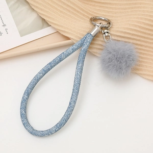 Detail of blue denim woven lanyard with gray pompom and silver metal clasp on knit base