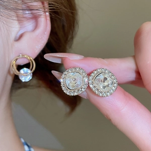 Detailed view of elegant gold stud earrings with sparkling cubic zirconia and crystals