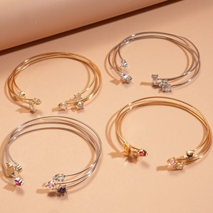 Lot de trois bracelets ouverts avec zircons, étoiles et gemmes carrées en or et argent poli