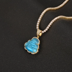 Close-up of golden Buddha pendant with blue stone and white zircon tennis chain necklace