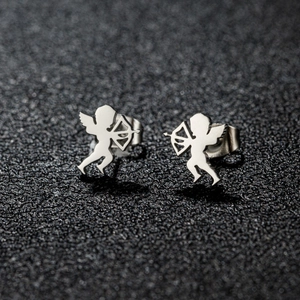 Macro shot of silver cupid angel stud earrings with bow and arrow on black background