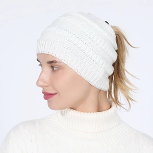 Detailed side view of white knitted ponytail beanie showing the top opening design