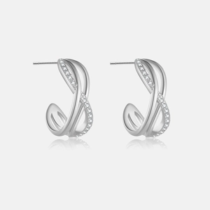 Macro shot of silver geometric cross earrings with micro-set cubic zirconia on grey background