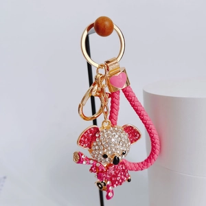 Close-up of pink crystal koala keychain with gold metal ring and braided strap detail