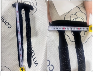 Detailopname van de meting die de hoge elasticiteit van glanzende panty met strass laat zien