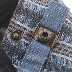 Close-up of checkered fabric and vintage bronze metal buckle with brand engraving