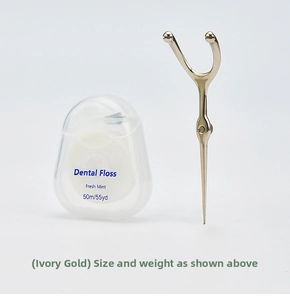 Macro detail of ivory gold stainless steel dental floss holder and mint dental floss set