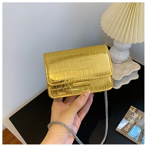Close-up of a gold crocodile pattern mini square bag with a metallic chain strap