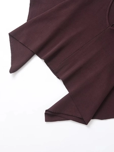 Dettaglio del tessuto in maglia marrone scuro con texture a coste morbida e verticale