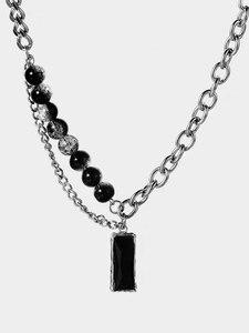 Detail of dark punk necklace with zircon pendant and asymmetric silver chains