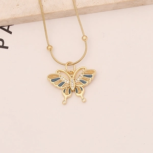 Close-up of butterfly pendant with blue enamel and pavé zircon on gold snake chain