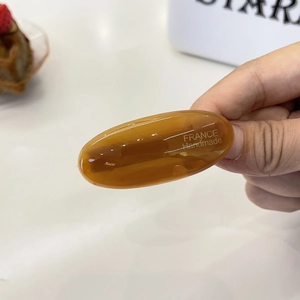 Elegant amber acetate oval hair clip with France Handmade lettering in soft light