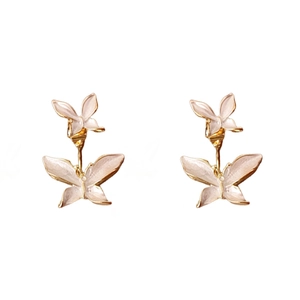 Élégantes boucles d'oreilles papillon dorées avec des ailes blanc nacré sur blanc