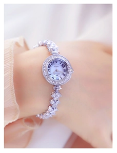Detail shot of luxury silver chain watch for women featuring sparkling rhinestones on wrist