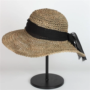 Elegant wide brim straw sun hat with a black chiffon bow for beach and travel
