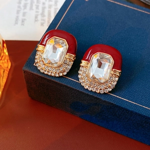 Detail of vintage French style gold-plated earrings with red enamel and zircon stones