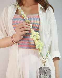 Detail of hand-woven daisy phone lanyard with yellow smiley flowers and metal clasp