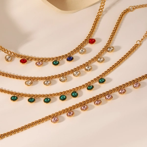 Bracelet doré en acier inoxydable avec charmes en zircon multicolore sur fond beige