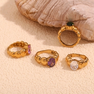 Close-up of vintage wide bubble rings with oval pink, purple, white and green gemstones