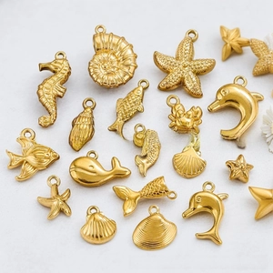 Detailed flat lay of golden stainless steel ocean charms including seahorse and starfish