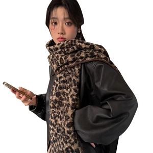 Women's leopard print faux wool scarf worn with a stylish brown leather jacket
