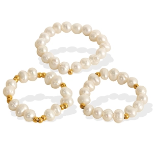 Set di tre anelli con perle naturali d'acqua dolce e accenti di perline dorate su sfondo bianco