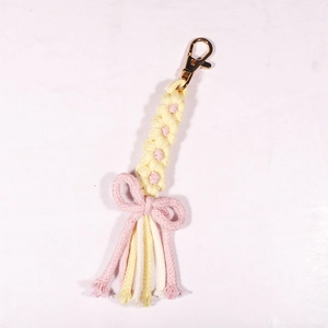 Handmade woven daisy keychain with pink tassels and a gold metal lobster clasp