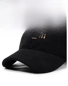 Detailed view of black baseball cap featuring golden MOUTH embroidery and waffle texture
