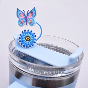 Detail of blue butterfly and sunflower silicone straw topper on a glass lid
