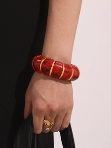 Detailed view of luxury resin marble red and 18k gold plated stainless steel cuff bracelet